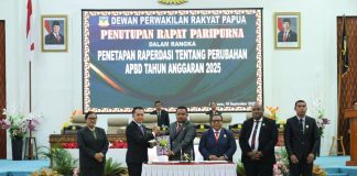 Caption : Ketua DPR Papua, Denny Henrry Bonai, ST. MM saat menyerahkan persetujuan APBD Perubahan 2025, kepada Penjabat Gubernur Papua, Agus fatoni di ruang siang sidang paripurna DPR Papua, Jumat (19/9/2025) malam.