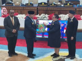 Caption : Wakil Ketua I DPR Papua, Herlin Beatrix Monim, didampingi Wakil Ketua III, Supriadi Paling, menyerahkan Dokumen Hasil Penetapan  Perdasus dan Perdasi kepada Wakil Gubernur Papua, Aryoko Rumaropen pada sidang paripurna DPR Papua, Jumat 9 Desember 2026.