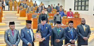 Bupati Jayapura, Dr. Yunus Wonda,SH,MH saat menyerahkan LKPJ TA 2025 kepada Ketua DPRK Jayapura, Ruddy Bukanaung,SE dalam sidang paripurna di Ruang Sidang DPRK, Selasa (29/4/26)
