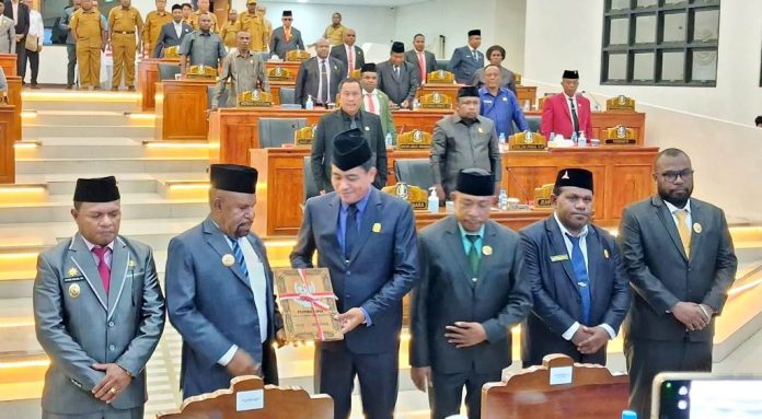 Bupati Jayapura, Dr. Yunus Wonda,SH,MH saat menyerahkan LKPJ TA 2025 kepada Ketua DPRK Jayapura, Ruddy Bukanaung,SE dalam sidang paripurna di Ruang Sidang DPRK, Selasa (29/4/26)