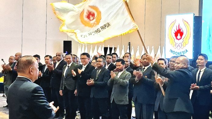 Komisaris Jenderal Polisi (Purn) Mathius D. Fakhiri, SIK, MH., saat menerima pataka KONI pada prosesi pelantikan sebagai Ketua Umum KONI Papua Periode 2026-2030