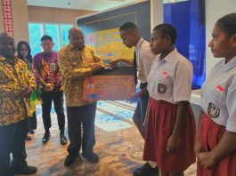 Gubernur Papua, Matius D. Fakhiri saat secara simbolis menyerahkan Kartu Pace dan Mace pada prosesi peluncuran Kartu Pace Mace, Jumat (12/6/2026)