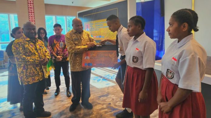 IMG-20260612-WA0005 Gubernur Papua, Matius D. Fakhiri saat secara simbolis menyerahkan Kartu Pace dan Mace pada prosesi peluncuran Kartu Pace Mace, Jumat (12/6/2026)