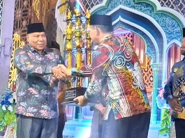 Wakil Gubernur Papua saat menyerahkan piala bergilir MTQ Tingkat Provinsi Papua kepada Plt. Sekda Kota Jayapura pada penutupan MTQ ke-31 di Sentani, Sabtu (18/7/26)
