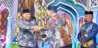 Wakil Gubernur Papua saat menyerahkan piala bergilir MTQ Tingkat Provinsi Papua kepada Plt. Sekda Kota Jayapura pada penutupan MTQ ke-31 di Sentani, Sabtu (18/7/26)