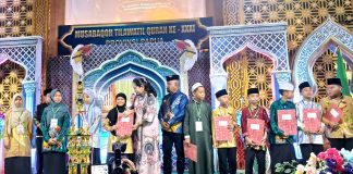 Bupati Jayapura Dr. Yunus Wonda, S.H., M.H. bersama Ibu saat menyerahkan sertifikat kepada peserta MTQ ke-31 yang berhasil meraih predikat terbaik