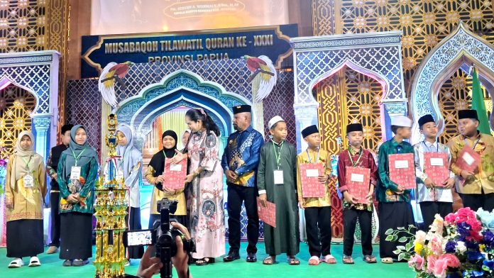 20260718_215813 Bupati Jayapura Dr. Yunus Wonda, S.H., M.H. bersama Ibu saat menyerahkan sertifikat kepada peserta MTQ ke-31 yang berhasil meraih predikat terbaik