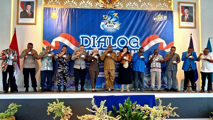 Dr. Stepi Anriani, Staf Khusus Menko Polkam RI turut menikmati Sagu olahan yang disantap dengan dicelup (papua: colo) ke minuman hangat pada pembukaan dialog kepemudaan KNPI Papua, Selasa (28/7/26)