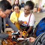 Regional CEO Bank Mandiri Region XII Papua, Antonius Budi Setiawan saat melakukan pembelian noken hasil kerajinan UMKM Mama-Mama Papua di arena Mandiri Vaganza Vol. 5 Auto Housing & UMKM Expo, Kamis (20/8/26)