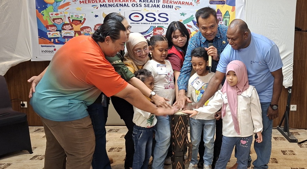Asisten II Bidang Perekonomian dan Pembangunan Setda Kabupaten Jayapura, Dr. Abdul Rahman Basri, Kepala DPMPTSP Kabupaten Jayapura, Gustaf Griapon, panitia, dan anak anak peserta lomba mewarnai saat menabuh tifa bersama pada pembukaan lomba mewarnai Logo OSS di Hotel Grand Papua Sentani, Sabtu (22/8/2026).