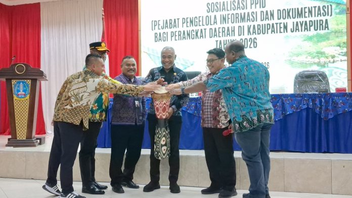 Pembukaan sosialisasi PPID bagi perangkat daerah di lingkungan Pemerintah Kabupaten Jayapura dengan pelabuhan tifa oleh Staf Ahli Gubernur Papua Bidang Pengembangan Masyarakat dan Budaya, Mathias Benoni Mano, S.Par., MKP., dan pejabat lain di Aula Lantai Dua Kantor Bupati Jayapura, Gunung Merah, Sentani, Kamis (24/9/26).