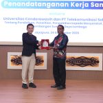 Direktur Human Capital Management Telkomsel, Indrawan Ditapradana menyerahkan cenderamata kepada Wakil Rektor III Bidang Kemahasiswaan dan Alumni Universitas Cenderawasih, Dr. Septinus Saa, S.Sos., M.Si.